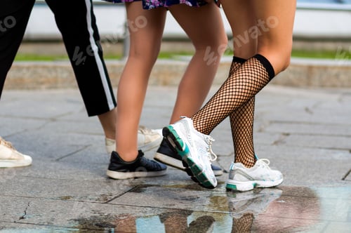 Preview: Three pairs of slim fit young girls legs in different sport shoes walking fast