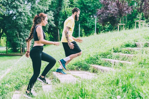 Aperçu: Couple d'un homme et d'une femme s'entraînant à courir à l'étage en plein air dans un parc