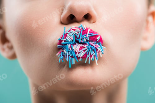 Preview: cropped view of woman with sprinkles on lips isolated on blue