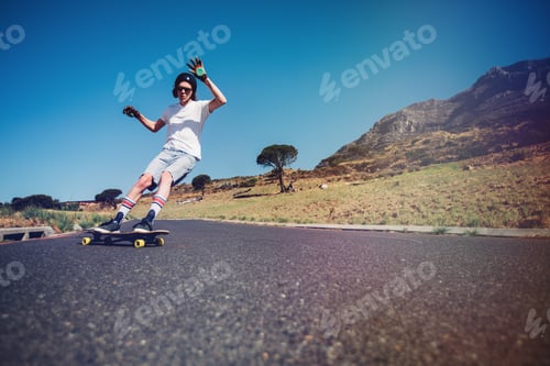 Preview: Young man longboarding on a road