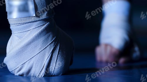 Preview: Sportsman doing push ups on his fists. Fists in bandages on the floor, the athlete push ups