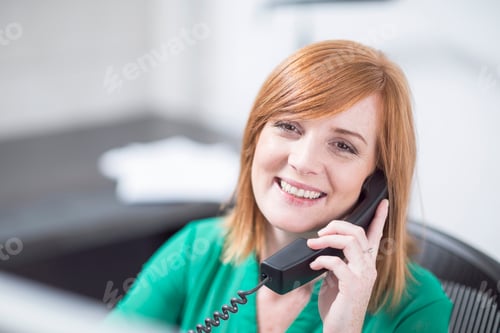Preview: Smiling businesswoman on the phone in office