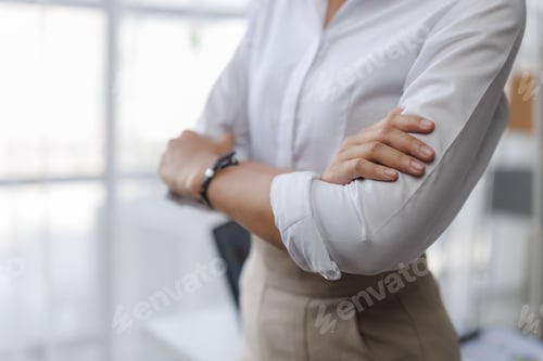 Preview: Businesswoman crossing arms, conveying confidence and professionalism