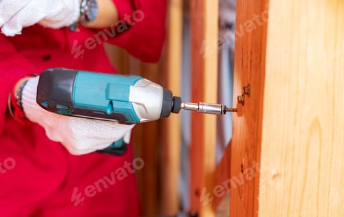 Preview: Carpenter and screwdriver hand tool. A skilled worker set to work drilling and installing wooden