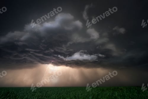 Preview: Landscape view of a stormy sky with lightning striking over a green field in Nebraska Plains,USA