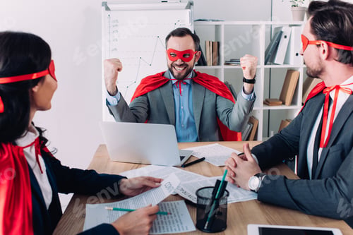 Preview: super businessman showing yes gesture to colleagues in office