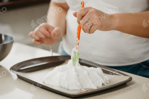 Preview: А Photo Of The Hands Of A Young Woman Who Is Improving With A Scapula A Shape Of A Giant Meringue