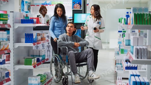 Preview: Young man wheelchair user talking to pharmacist about medicaments