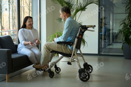 Vorschau: Patient im Rollstuhl kommuniziert mit Krankenschwester auf der Couch