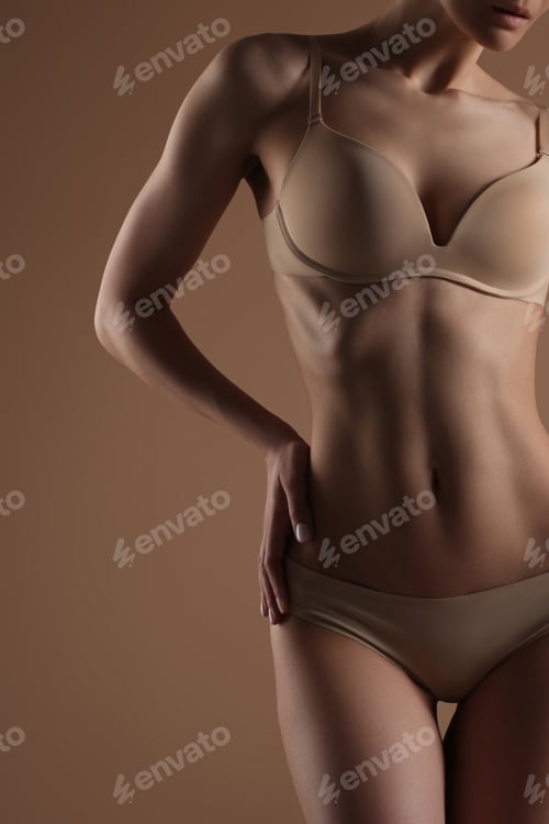 Preview: Thin young woman in underwear on beige background