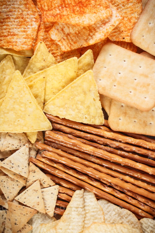 Preview: Heap of salted crisps, breadsticks and cookies, concept of unhealthy food