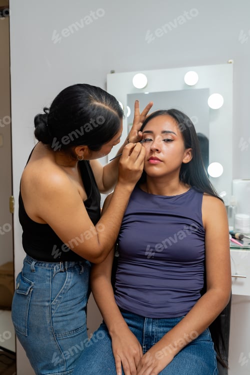 Preview: Makeup artist applying eyeliner on young woman