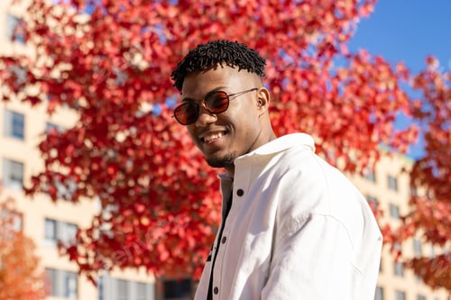Preview: Smiling Man in an Urban Setting with Red Leaves