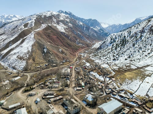 Preview: High-angle view of Ming-Kush village in a snow-dusted, rugged mountain valley