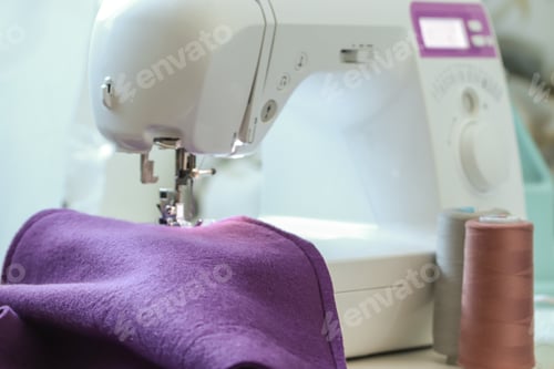Preview: A woman sews children's clothes on a sewing machine. Hands of a seamstress. seamstress profession