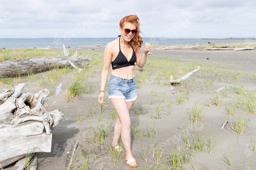 Preview: Pretty woman with red hair and freckles at the ocean beach