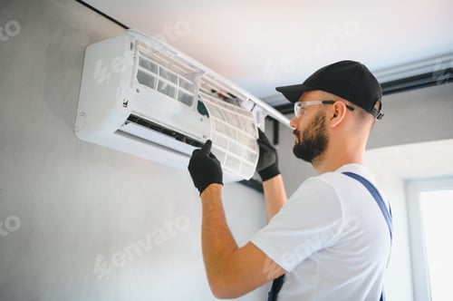 Preview: Technician man in uniform installing, repairing air conditioner. Construction and repair concept