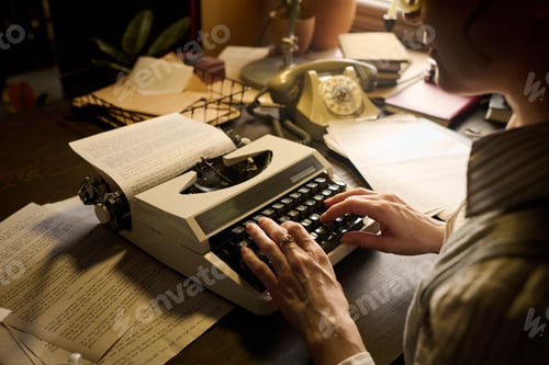 Preview: Caucasian Young Adult Woman Typing Manuscript on Vintage Typewriter Indoors