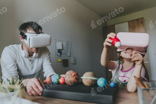 Preview: Little girl having fun time with her father using VR glasses