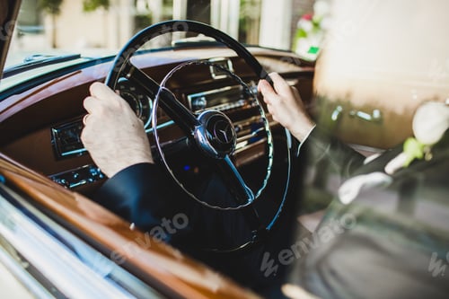 Preview: Detail of the hand of a driver of a luxury classic car.