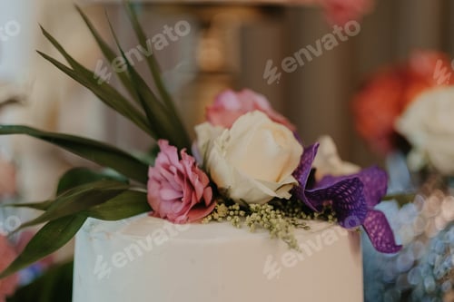 Preview: Closeup shot of a beautiful flower bouquet on a white cake for a luxurious event