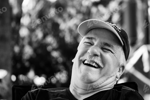Preview: Grayscale closeup of a laughing man with a cape.