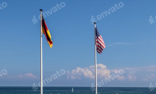 Preview: American flag and a German flag waving together in the air