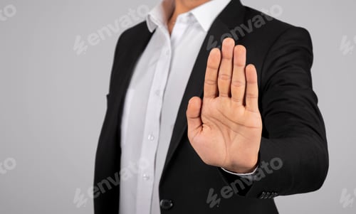 Preview: Man In Suit Showing Open Palm At Camera, Gesturing Stop