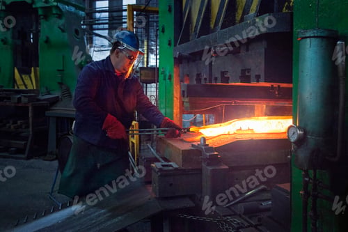 Preview: Skilled worker forging metal in industrial environment.