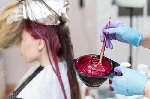 Preview: hairdresser makes hair coloring to young girl