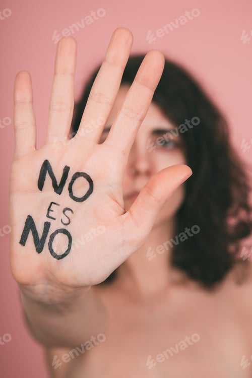 Preview: Young caucasian woman protesting against rape. No means no vindictive letters painted on hand palm.