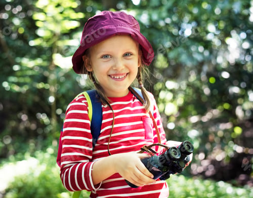 Preview: Little girl using binoculars in the forest