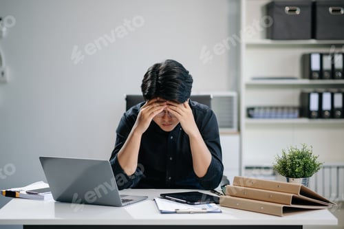 Preview: Businessman who is tired and overthinking from working with tablet and laptop