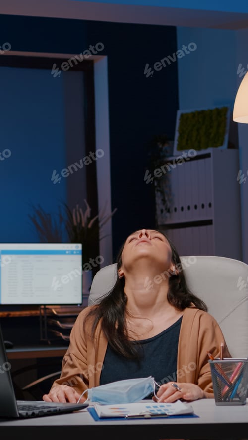 Preview: Overworked entrepreneur with face mask against covid19 working in startup office
