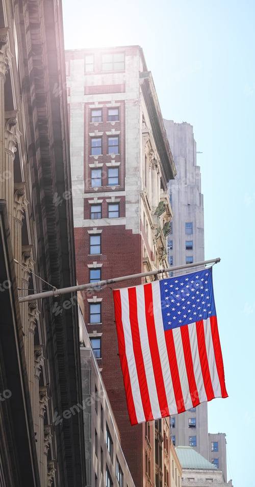 Preview: American flag with buildings in background, selective focus, New York City, USA.