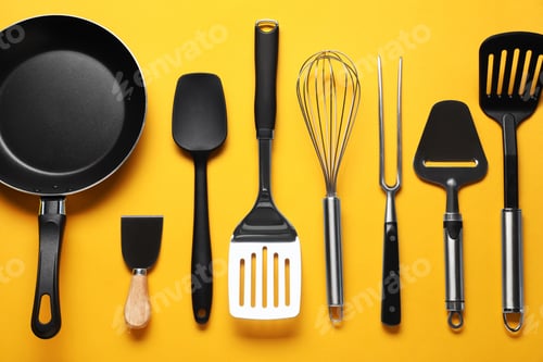 Preview: Different spatulas and other kitchen utensils on orange background, flat lay