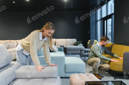 Preview: Couple choosing sofa and pillows at furniture store