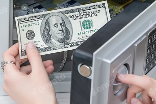 Preview: a woman's hand pulls out dollars from the safe