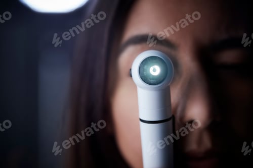 Preview: Female doctor using otoscope for examination, close up