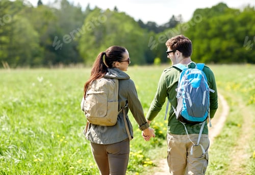 Preview: happy couple with backpacks hiking outdoors