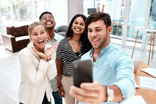 Preview: Cropped shot of a group of young business colleagues taking selfies in their office