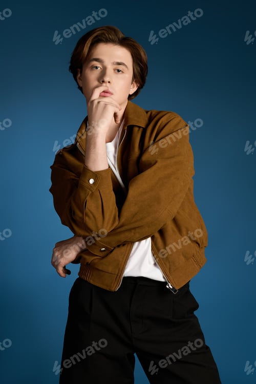 Preview: Young fashionable man posing confidently against a solid blue background