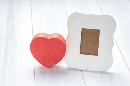 Preview: White vintage frame with red heart gift box on white wood table