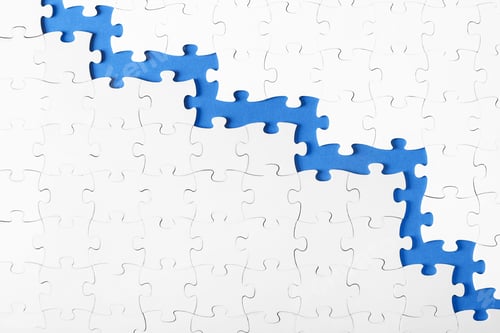 Preview: White puzzles on blue background top view with copy space