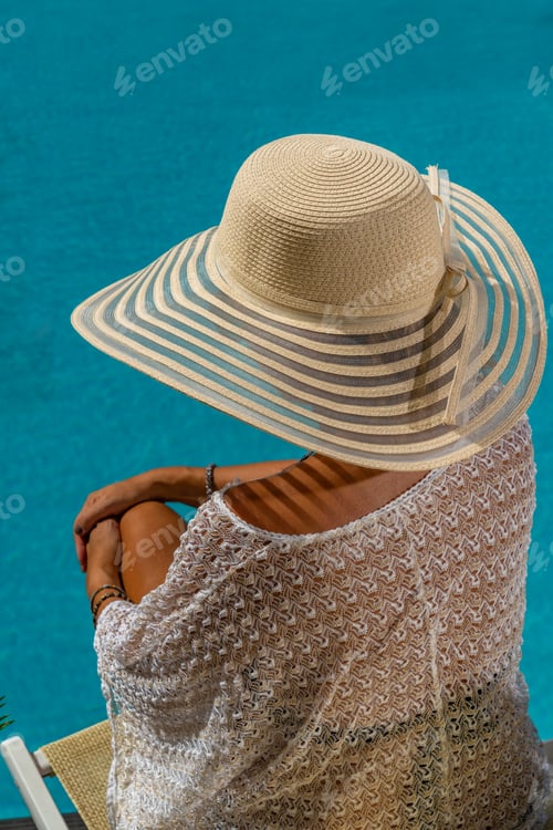 Preview: woman at spa resort by the swimming pool.