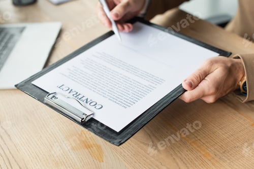 Preview: partial view of blurred businessman signing contract in office, anti-corruption concept