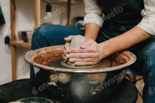 Preview: Shaping clay earthenware on potters wheel. Craftswoman molds wet clay in workshop