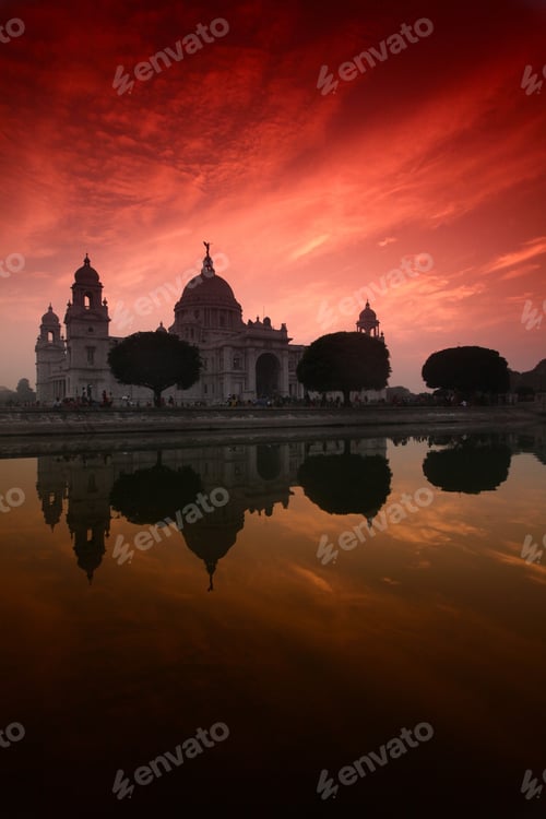 Preview: Vertical shot of Victoria Memorial in Calcutta, India reflected in the water under the colorful sky