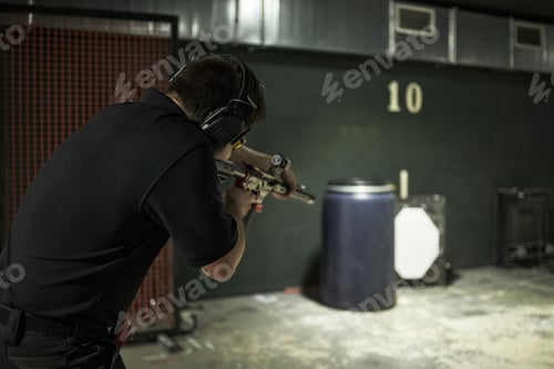 Preview: Young Man Practicing Shooting Rifle at Indoor Sports Club