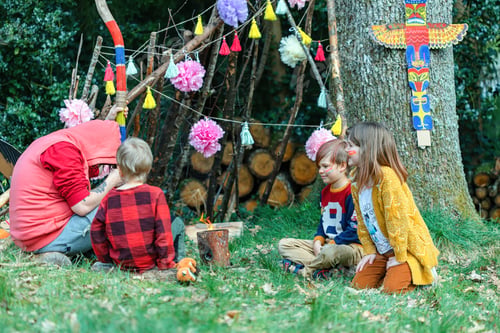 Preview: children playing Indians near a hut made of branches, candle fire from a log